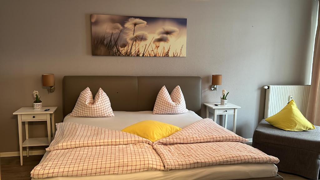 Comfort Family Apartments في فيلاخ: غرفة نوم بسرير مع مخدات صفراء وردية