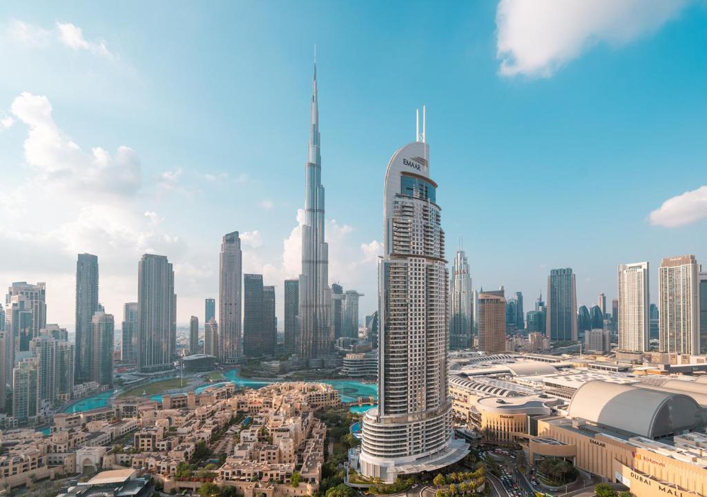 BURJ ROYALE - Luxury 2 bedroom apartment with full burj Khalifa & fountain view- DELUXE في دبي: اطلالة على مدينة فيها ناطحة سحاب طويلة