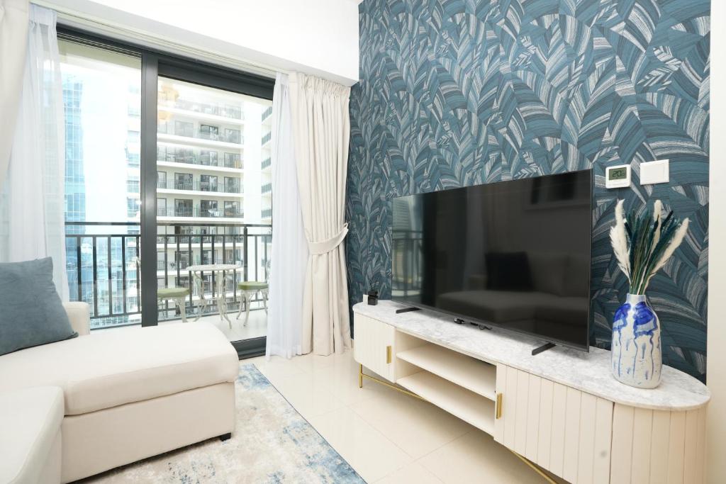 a living room with a couch and a large screen tv at Cozy Flat in Business Bay in Dubai