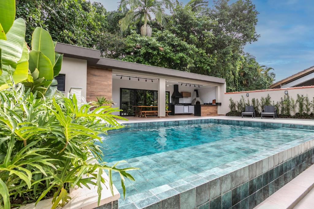 a swimming pool in the backyard of a house at Casa perfeita pro verão e inverno na Riviera in Bertioga