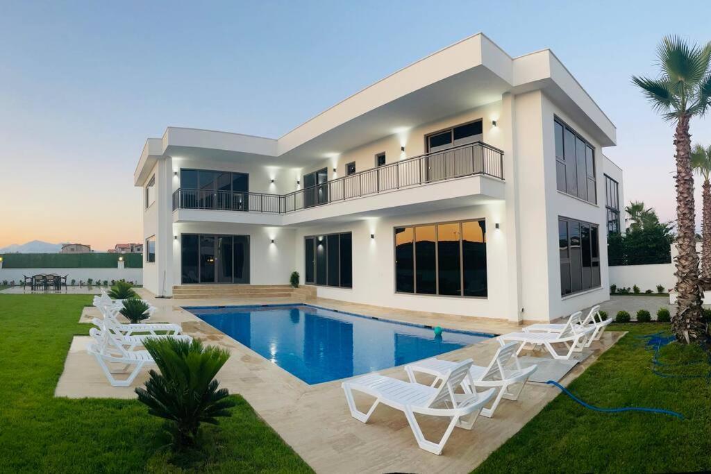 une maison avec une piscine et des chaises blanches dans l'établissement Villa Blue - New Luxury Villa, à Belek