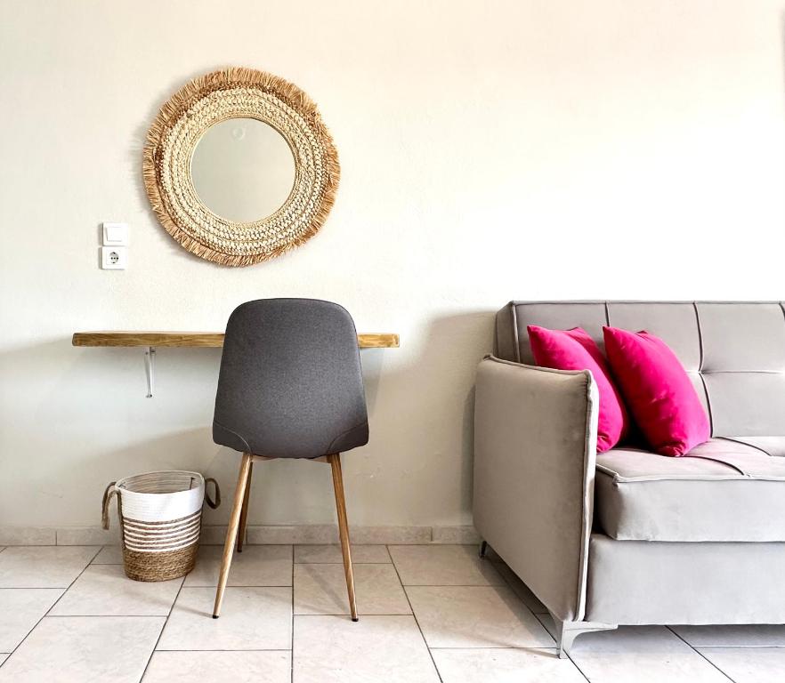 einen Stuhl im Wohnzimmer mit Sofa und Spiegel in der Unterkunft Harma Corfu in Sidari