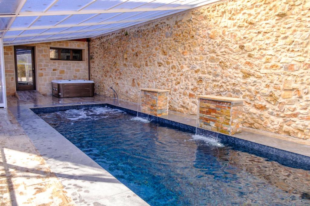 an indoor swimming pool with a stone wall at Apartamentos & Wellnes LA QUIMERA DE AITANA Burgo de Osma in El Burgo de Osma