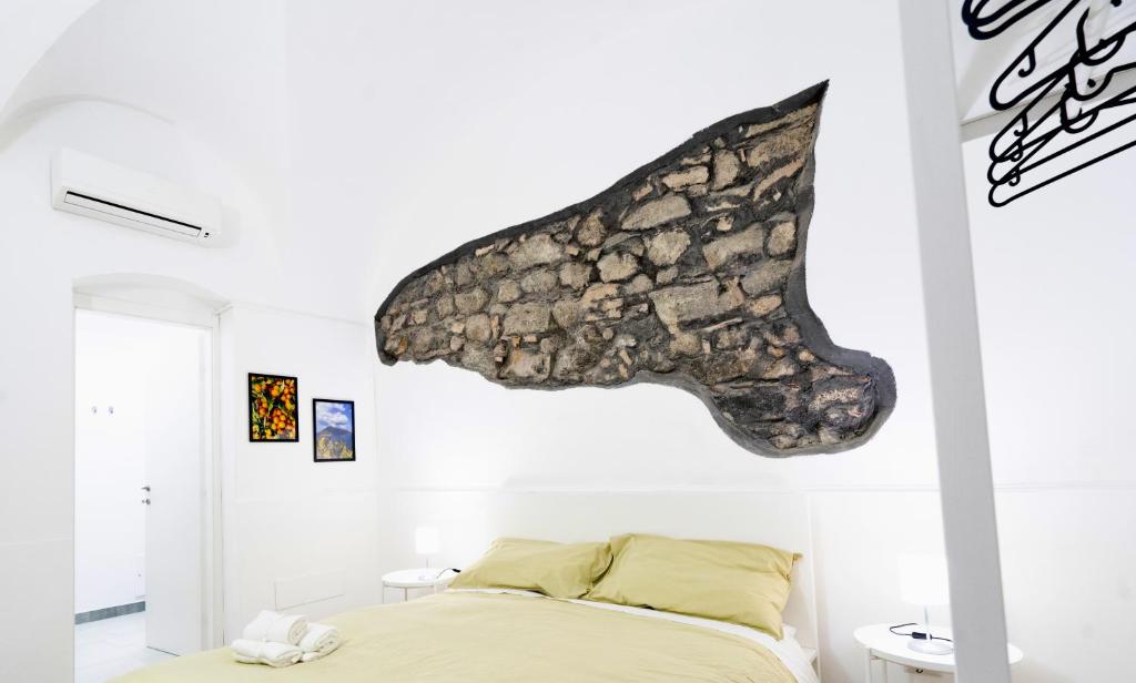 a bedroom with a bed with a fish on the wall at Be happy Rooms in Catania