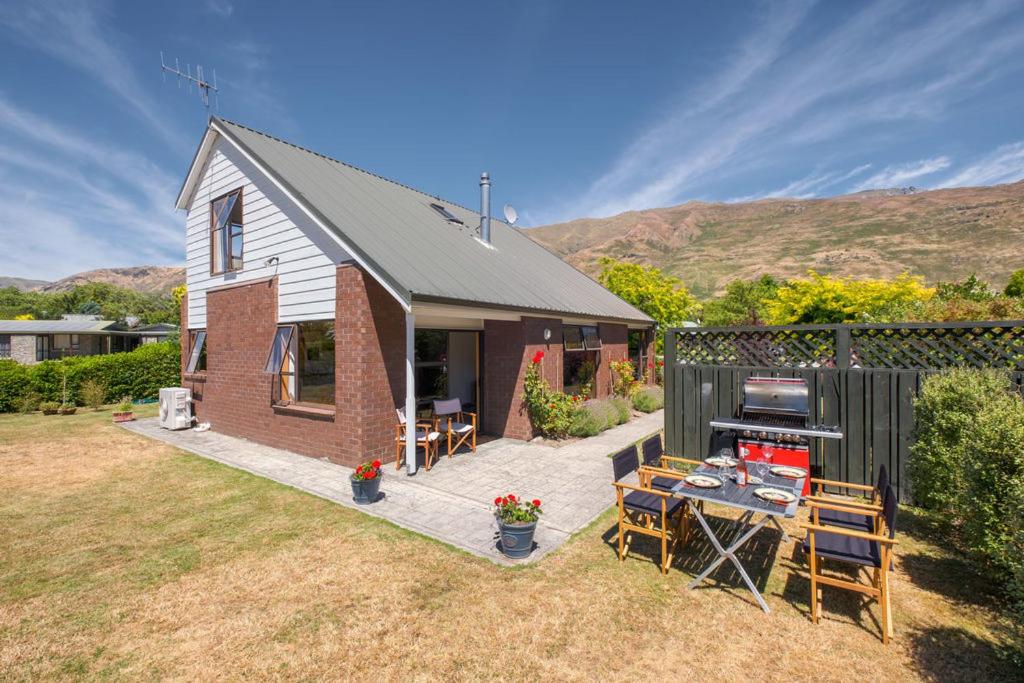 a small house with a table and a grill at Wanaka Tranquility - Wanaka Holiday Home in Wanaka