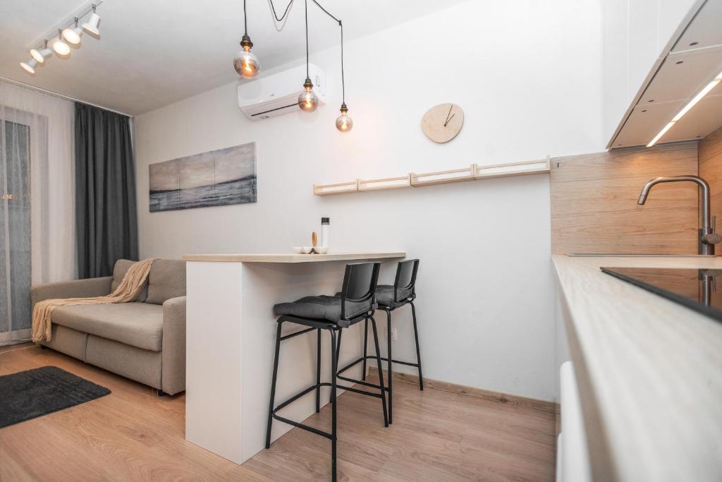 uma cozinha e sala de estar com um bar e um sofá em City Center Apartment - Modern & Elegant em Bratislava