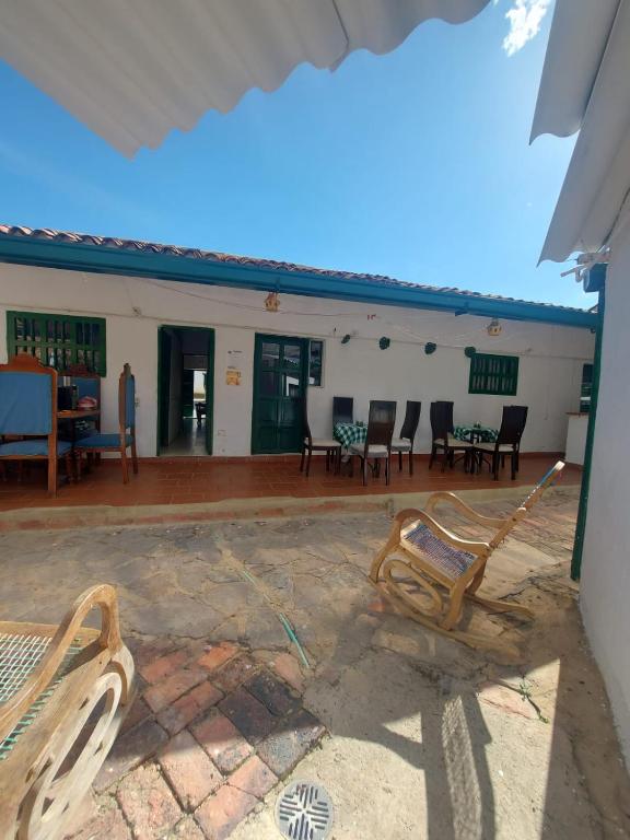 een patio met stoelen en tafels en een gebouw bij POSADA CASA MIA in Villa de Leyva