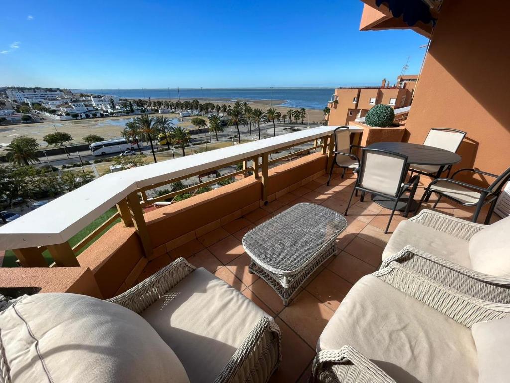 Un balcón con sillas y vistas al océano. en Mirador de Sanlucar 6, en Sanlúcar de Barrameda