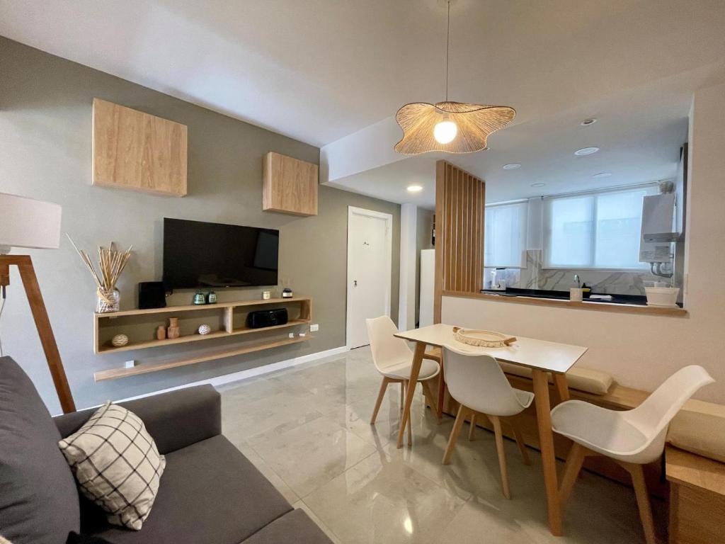 a living room with a table and a couch and a television at Depto Las Heras -tucasaenmdp in Mar del Plata
