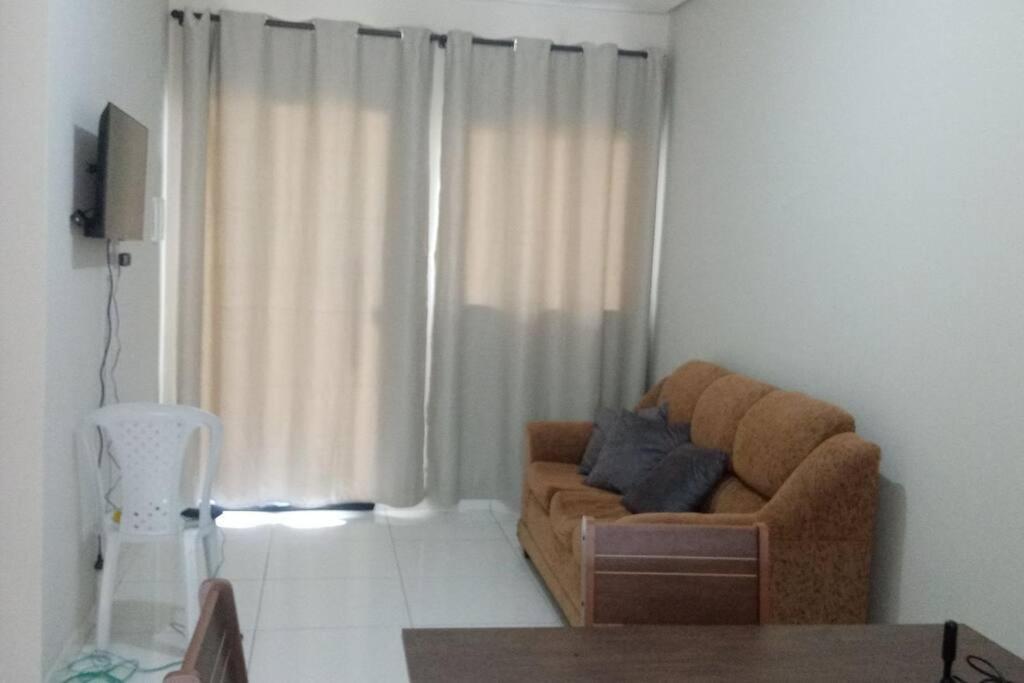 sala de estar con sofá marrón frente a una ventana en Casa Mobiliada Nova em Petrolina, en Petrolina