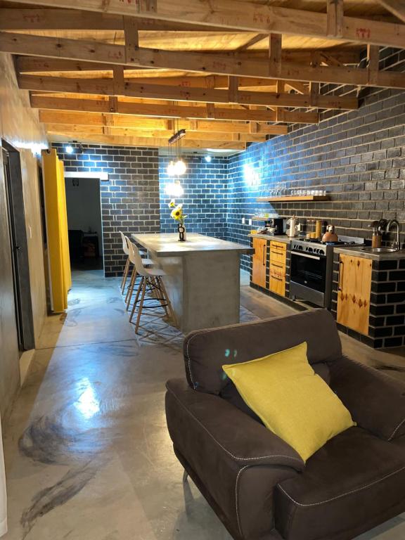 ein Wohnzimmer mit einem Sofa und einer Küche in der Unterkunft Vintage Corner Accomodation in Walvis Bay