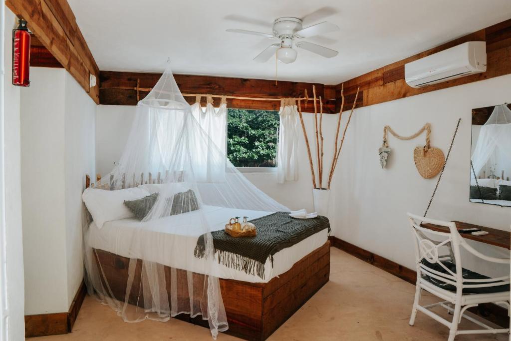 a bedroom with a bed with a mosquito net at Icástico Tulum in Tulum