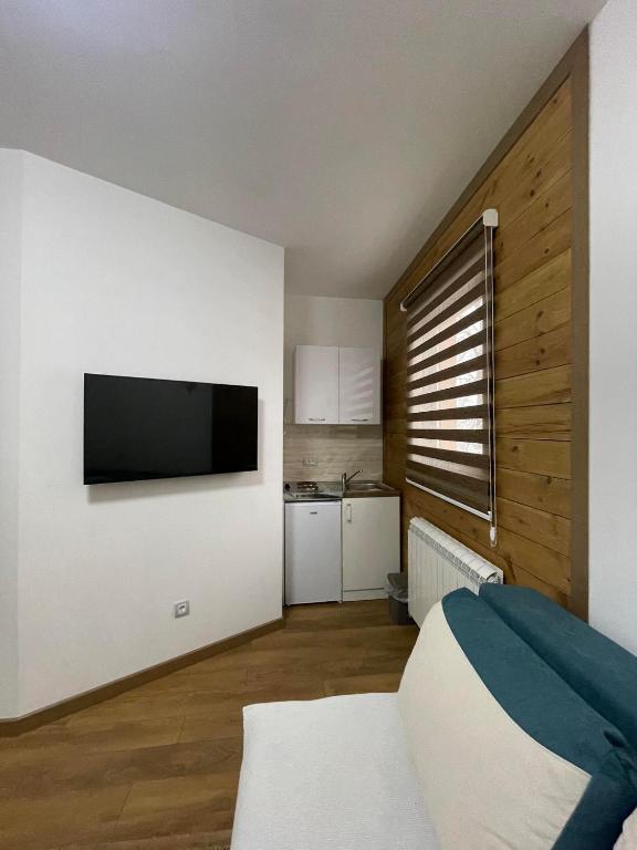 a bedroom with a bed and a flat screen tv at Apartmani Dino Kolasin in Kolašin