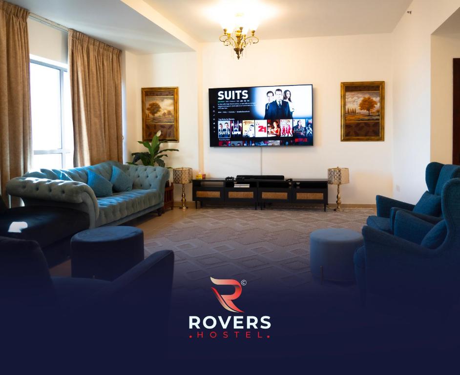 a living room with couches and a flat screen tv at Rovers Hostel Dubai in Dubai