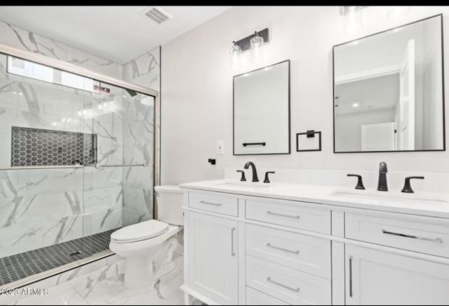 a white bathroom with a shower and a toilet and sink at La casa de Reymar in Phoenix