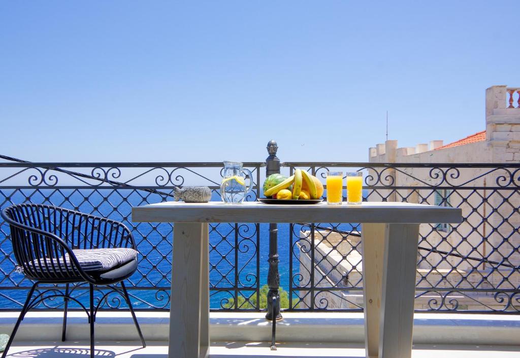 a table with fruits and drinks on a balcony at Lydia in Ermoupoli