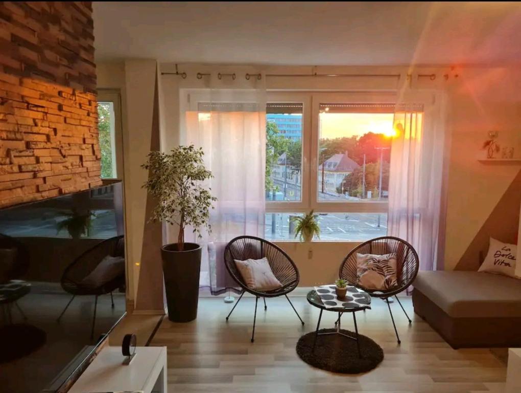 uma sala de estar com cadeiras, um sofá e uma janela em Apartment in TOP Lage Durlacher Tor/KIT em Karlsruhe