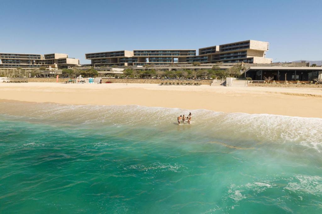 dos personas están en el agua en la playa en Solaz, a Luxury Collection Resort, Los Cabos en San José del Cabo