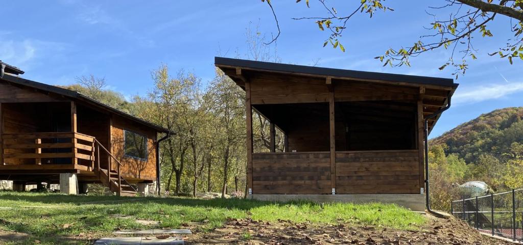 ein Holzgebäude in der Mitte eines Feldes in der Unterkunft Bungalouri Olanesti in Băile Olăneşti