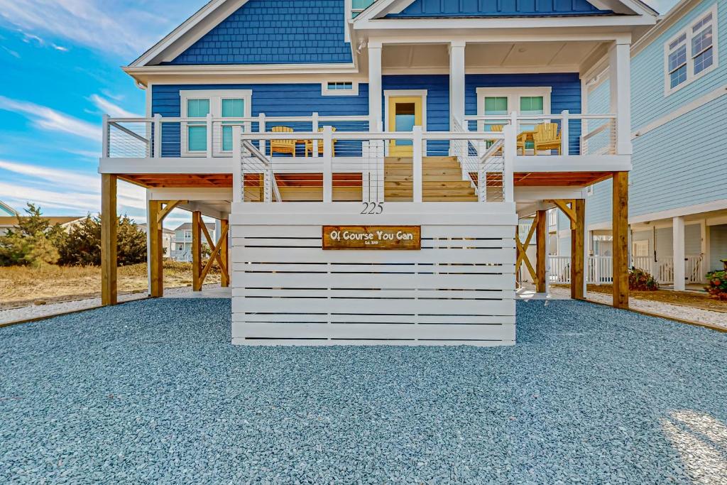 a house with a deck on a driveway at Of Course You Can in Holden Beach