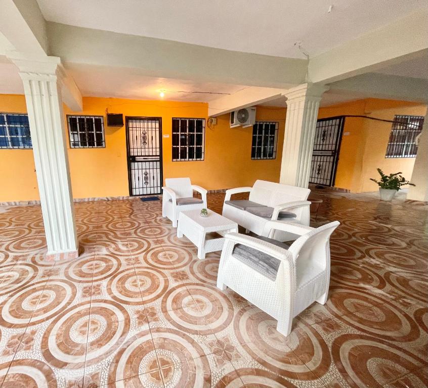 a large room with white chairs and columns at MI SEGUNDO HOGAR in Ensanche Ozama