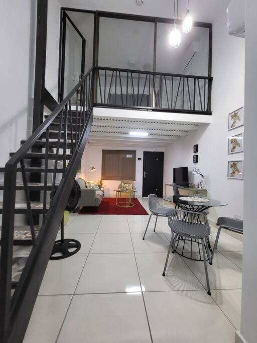 a living room with a staircase and a table and chairs at Apartamento #6 cómodo, Tranquilo, Elegante cerca de la estación del metro de la cincuentenario in Panama City