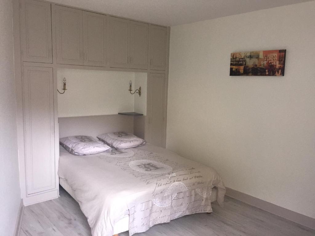 1 dormitorio con 1 cama blanca y armario en Bel cantou, en Royat