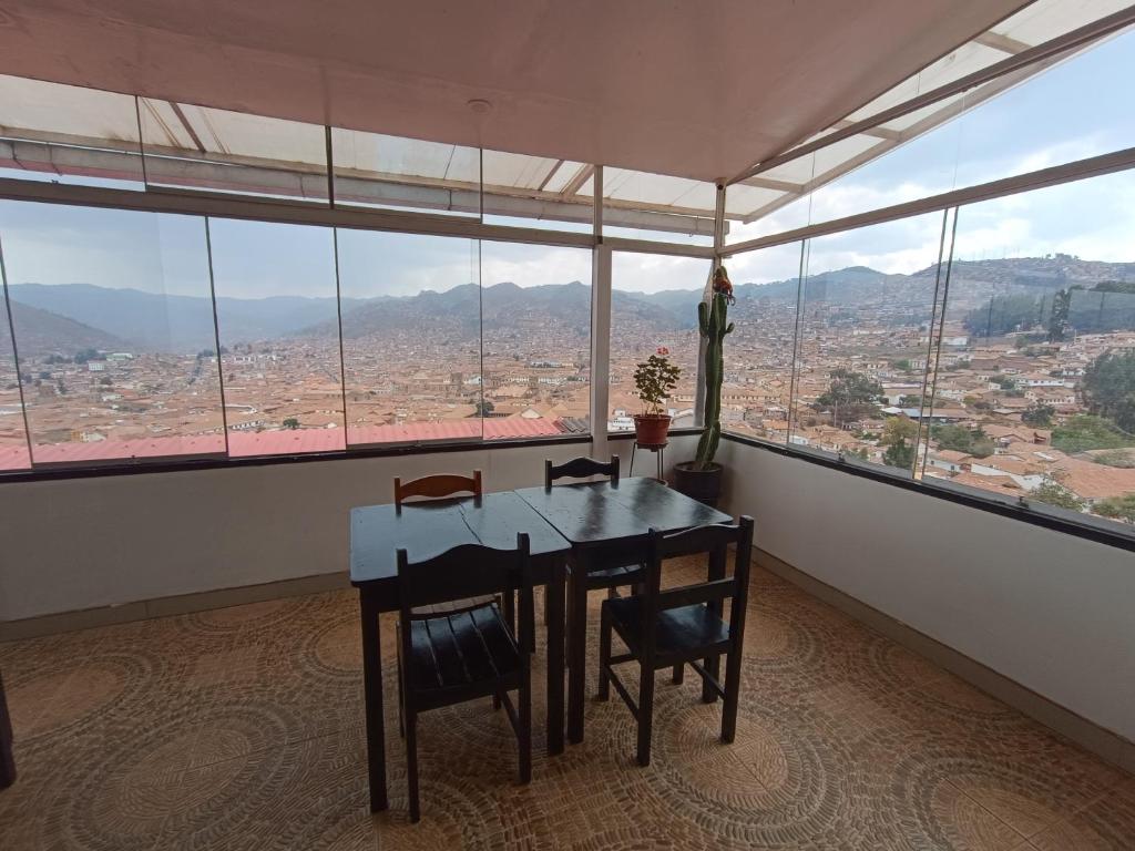 a dining room with a table and chairs and windows at Apartamento Mirador San Blas in Cusco