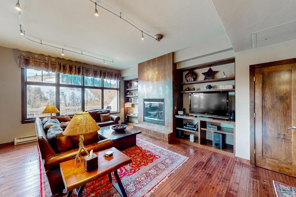 a living room with a couch and a tv at Howelsen Panoramic Views in Steamboat Springs