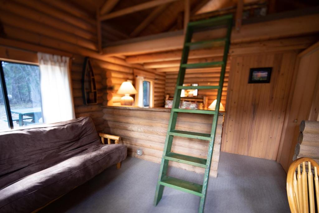 uma escada verde num quarto com um sofá em Experience Montana Cabins - Wildflower #3 em Bigfork