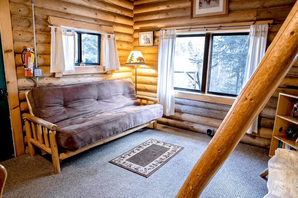 a living room with a couch in a log cabin at Experience Montana Cabins - Cowboy #5 in Bigfork