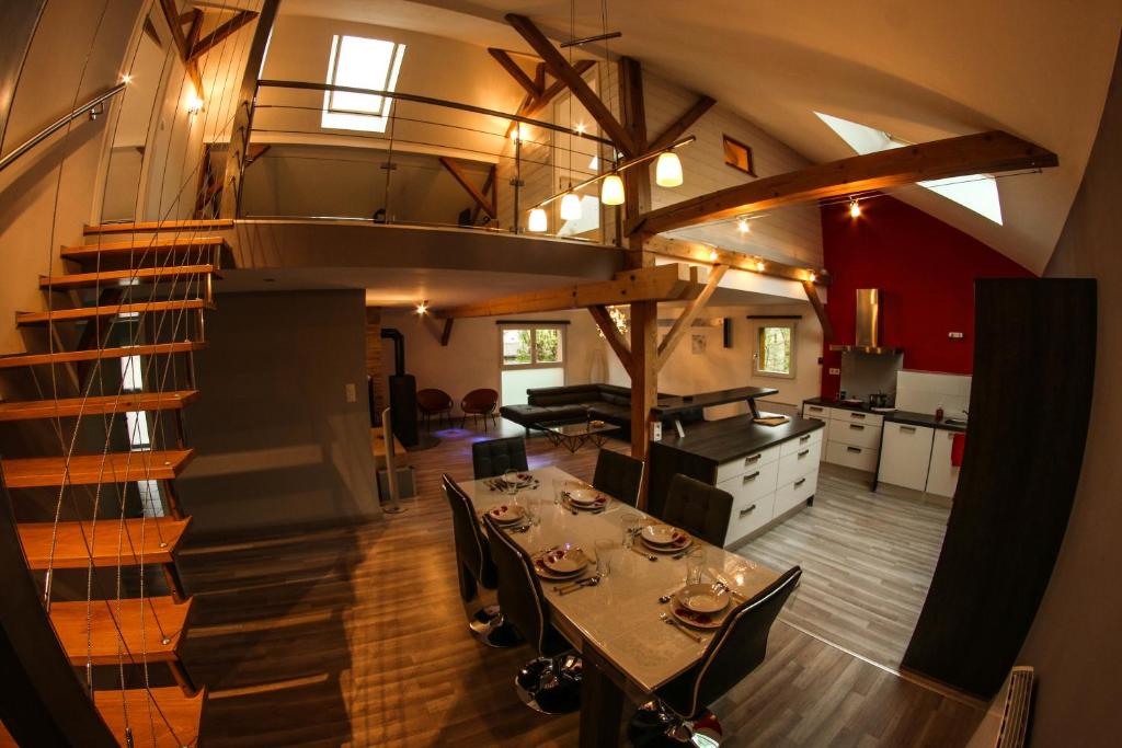 cocina y comedor con mesa y escalera en L'Atypique Vosgien, en Bussang