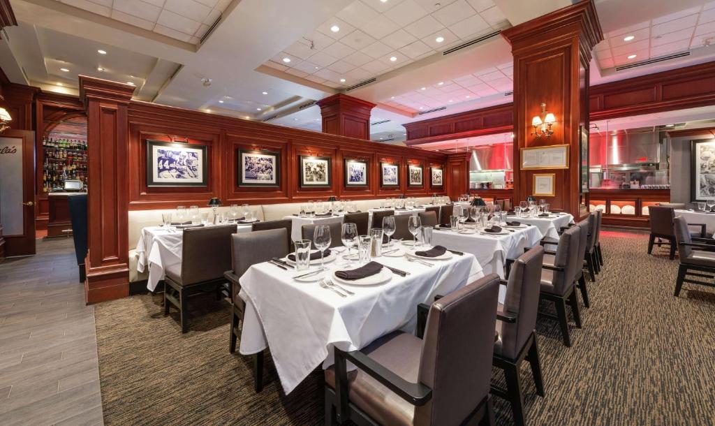 a dining room with white tables and chairs at Hilton Naples in Naples