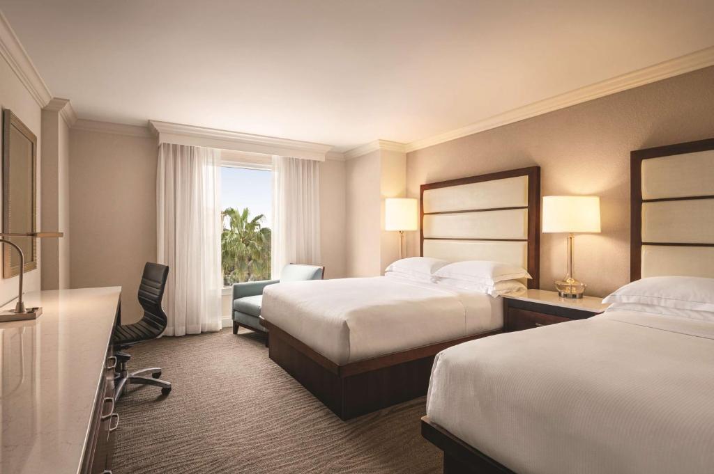 a hotel room with two beds and a window at Hilton Naples in Naples