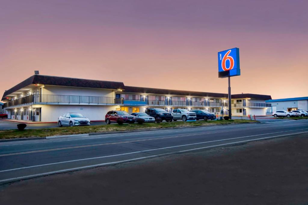 un edificio con coches estacionados en un estacionamiento en Motel 6-Farmington, NM, en Farmington