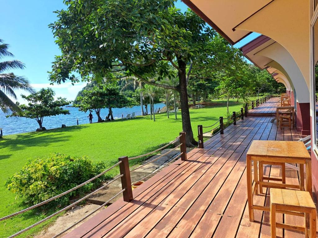 una terraza de madera con mesa y sillas. en Lomtalay Resort Trat, en Ban Bang Pit Lang