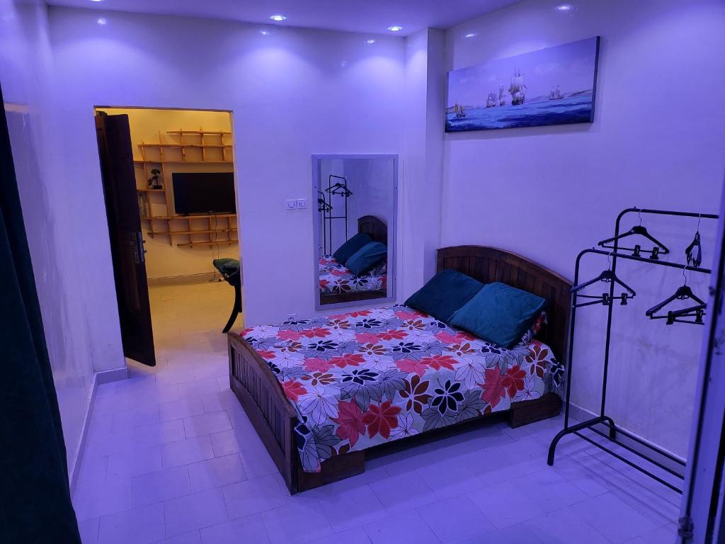 een slaapkamer met een bed en een spiegel bij Studio indépendant virage in Dakar