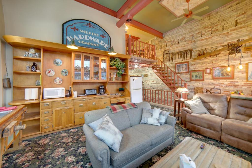 Historic Downtown Saugatuck Loft Apartment! في ساوغاتوك: غرفة معيشة مع أريكة ومطبخ