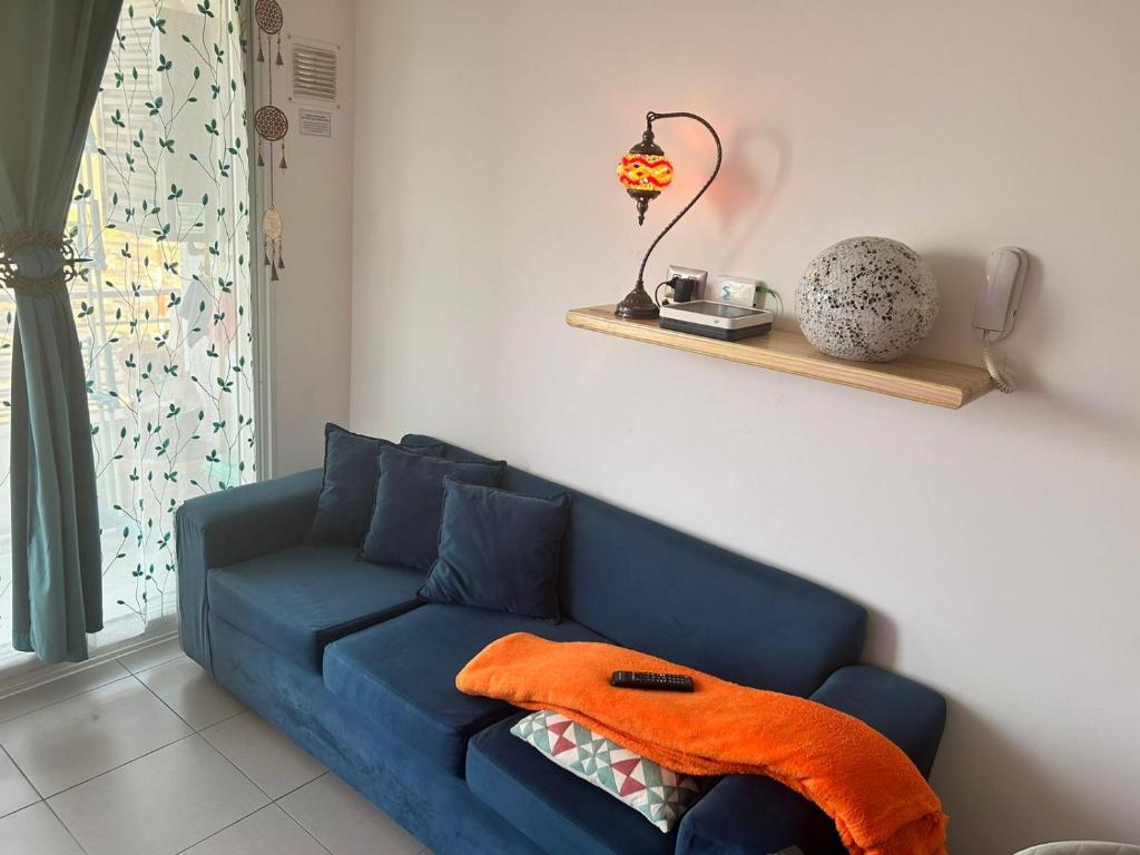 a blue couch in a living room with a lamp at Arriendo diario departamento completamente amoblado in Iquique