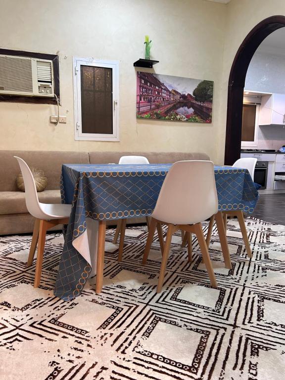 a dining room with a table and chairs on a rug at فيلا الوريك Villa Al Warik in Umm Lajj