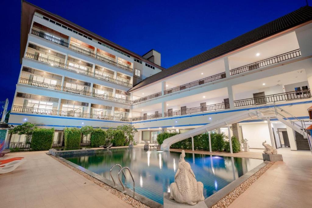 an external view of a building with a swimming pool at Napalai Resort & Spa in Hua Hin