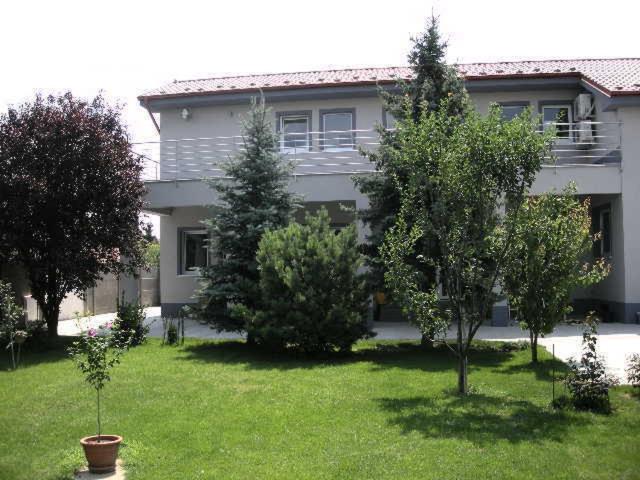a house with trees in front of a yard at Ubytovanie House in Galanta