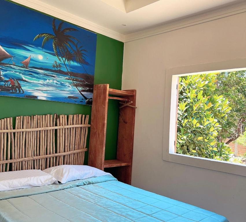 um quarto com uma pintura na parede e uma cama em Suíte em Sítio a 5 minutos da praia em Porto Seguro