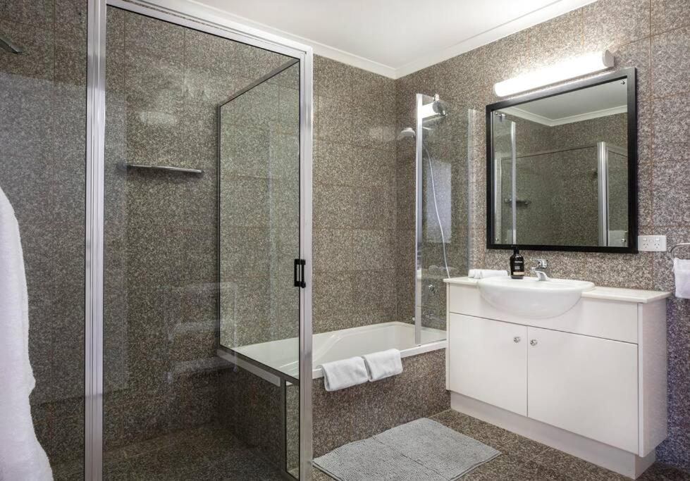 y baño con ducha, lavabo y bañera. en SEA FOR MILES at Semaphore to relax & unwind, en Semaphore