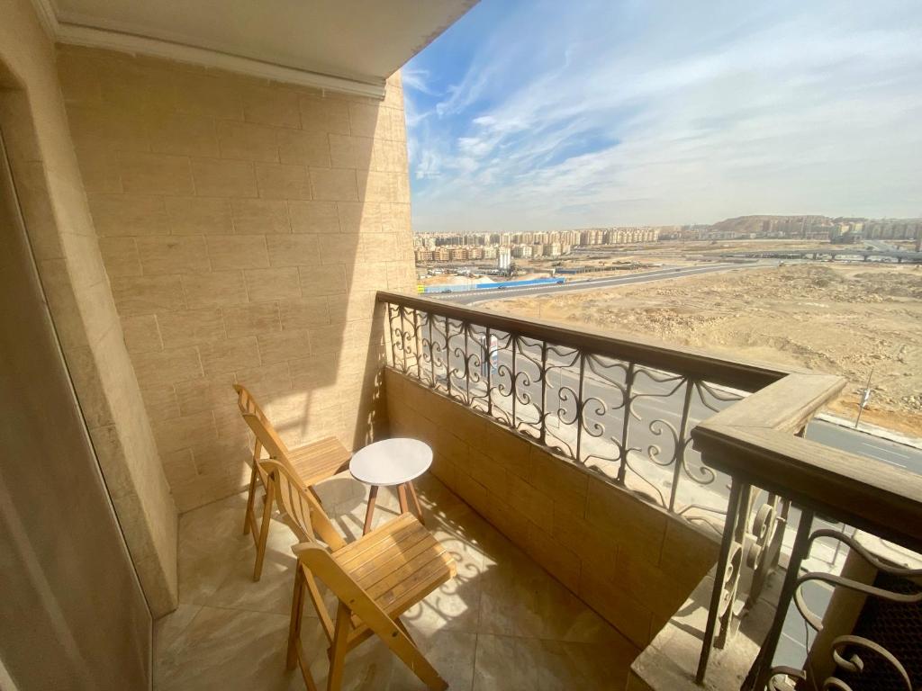 a balcony with two chairs and a view of the desert at Cozy 3BR Apartment in Maadi in Cairo