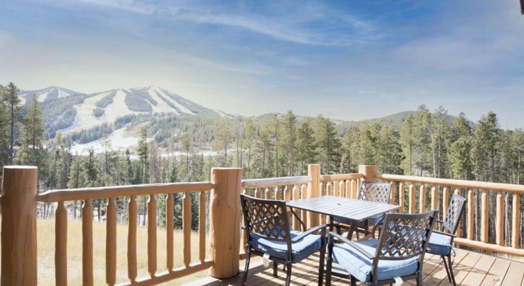 a table and chairs on a deck with a view of mountains at Antler Way at Lakota,,,, townhouse in Winter Park
