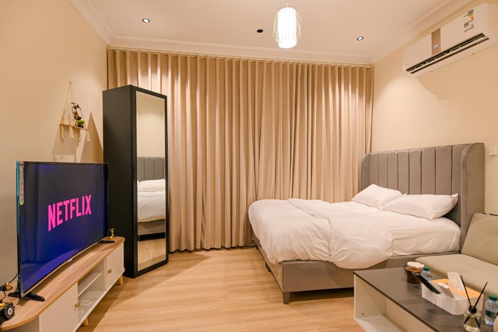 een hotelkamer met een bed en een televisie bij استديو بمدخل ذاتي وموقع مميز in Riyad
