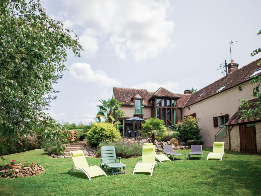 a yard with chairs and a house at Gîte de charme avec SPA et cheminée, près du Mans, 7 chambres, WIFI, en bord de forêt de Vibraye - FR-1-410-308 in Dollon