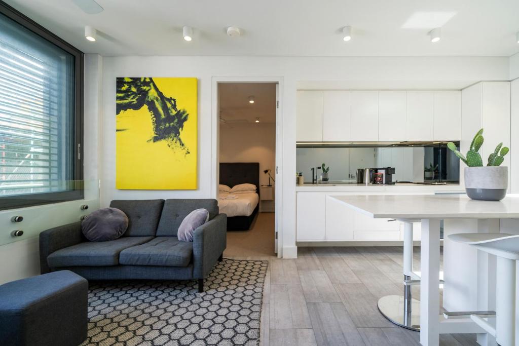a living room with a couch and a kitchen at EIGHT TWO NINE TWO V: BONDI BEACH in Sydney
