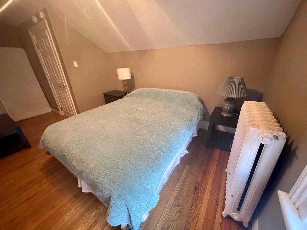 ein Schlafzimmer mit einem Bett und einem Tisch mit einer Lampe in der Unterkunft ROOM D IN THE WHITE HOUSE in Niagara Falls